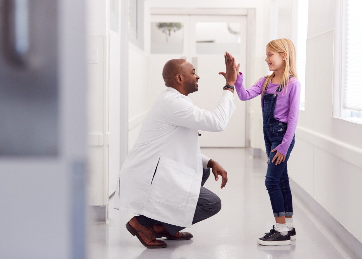 male-paediatric-doctor-giving-young-girl-patient-1240-886